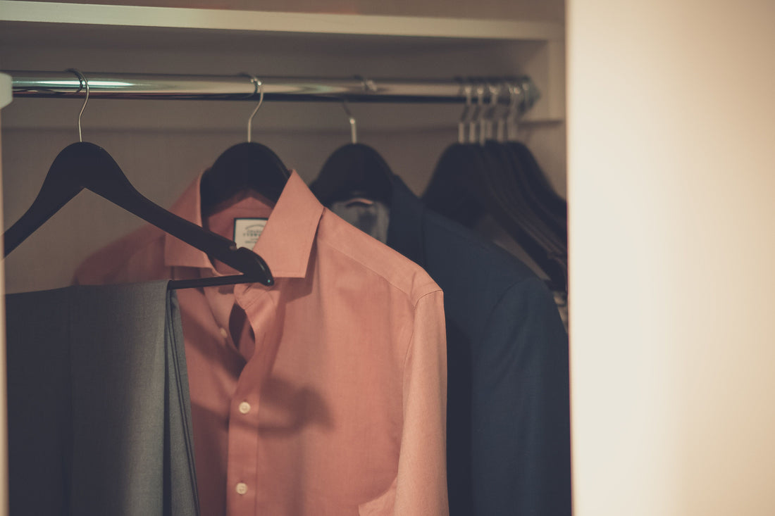 Shirt and suit pants hanging neatly in a closet