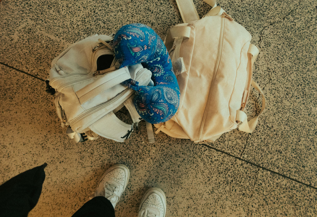 Travel neck pillow next to a backpack and luggage at the airport