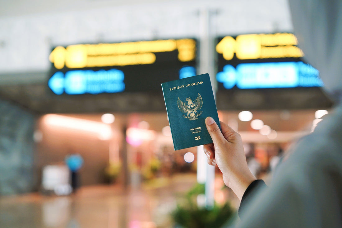 Traveler holding up a passport in an airport terminal
