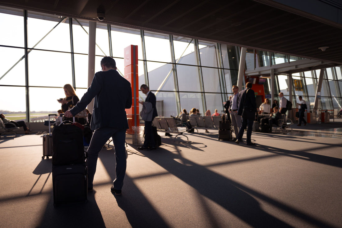 Business travelers walking through an airport terminal with luggage