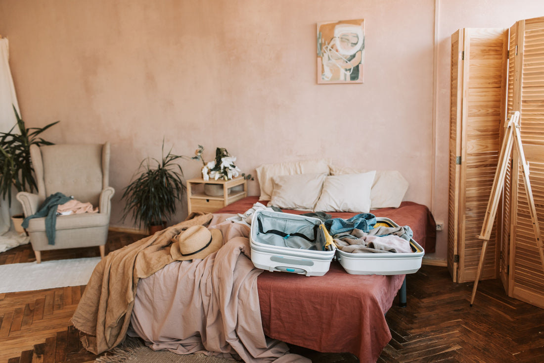 Open suitcase packed on a bed in a cozy bedroom