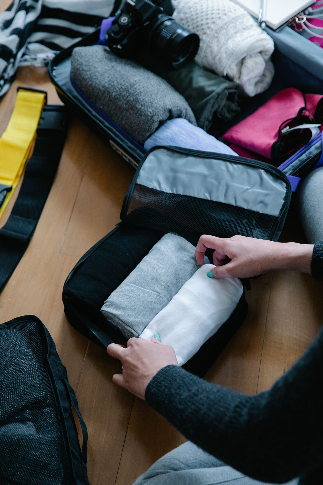 Hands packing a compression cube into an open suitcase